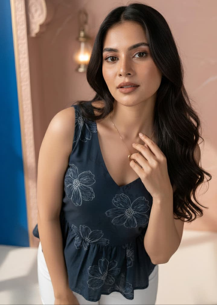 Woman wearing a dark blue floral top in an ornate setting