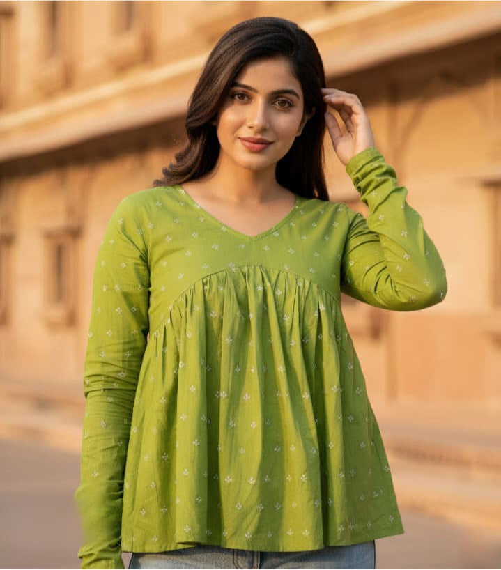 Woman wearing a green blouse with a blurred background